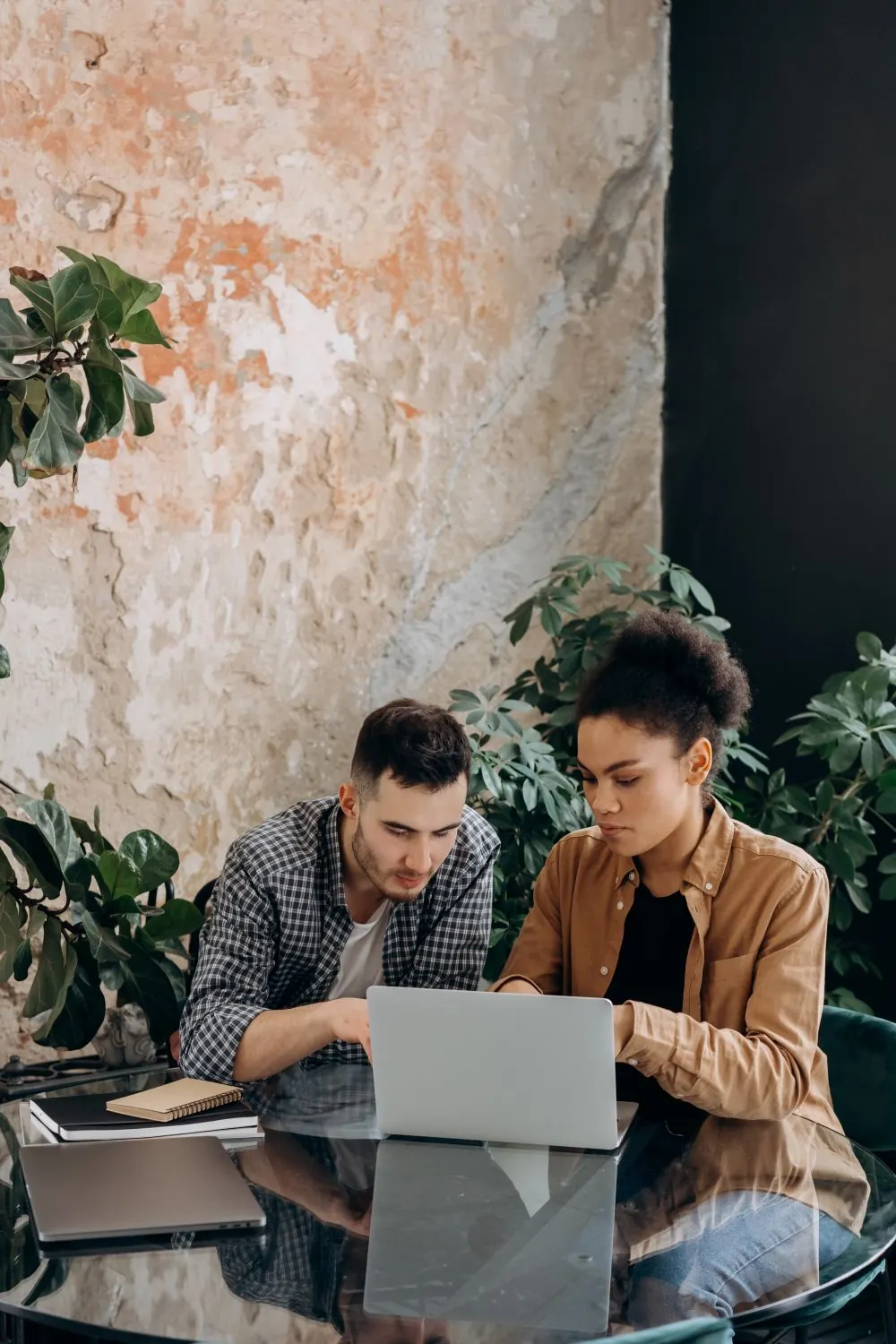 Two young professionals working together on a laptop