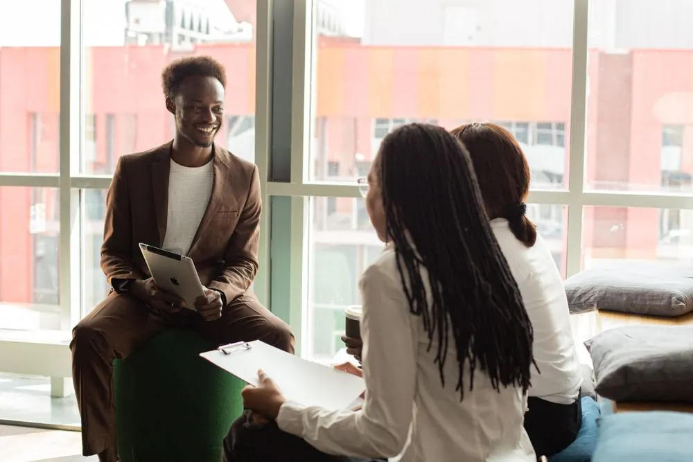 A founder and an adviser discussing a business plan by a window