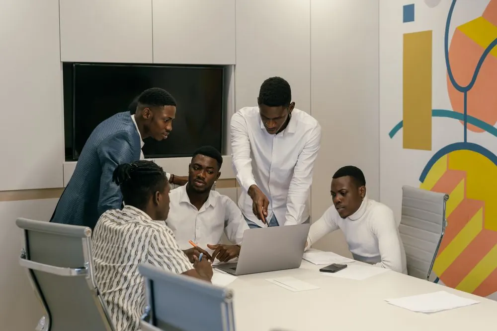 A young team gathered around laptops during a workplace meeting